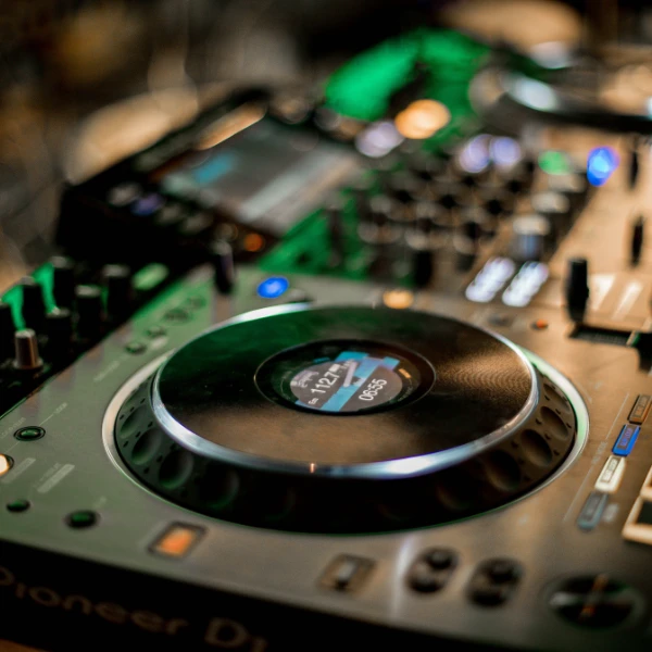 Close-up of a Pioneer DJ jog wheel with its display lit in a club DJ booth