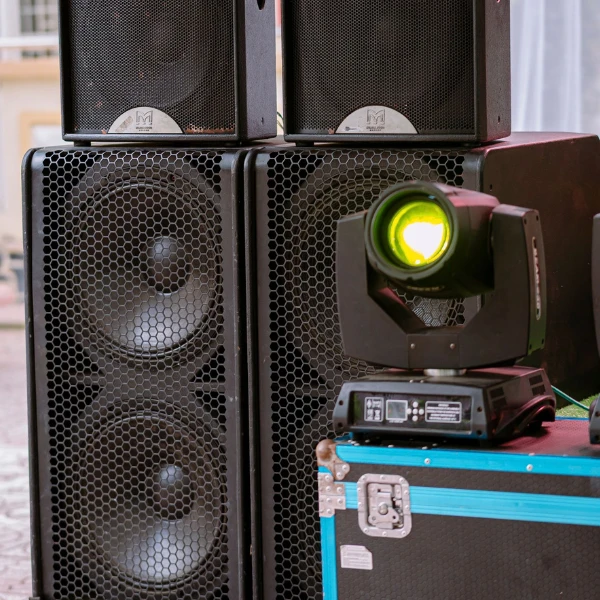 PA speakers stacked on subwoofers with a moving head light at an outdoor event